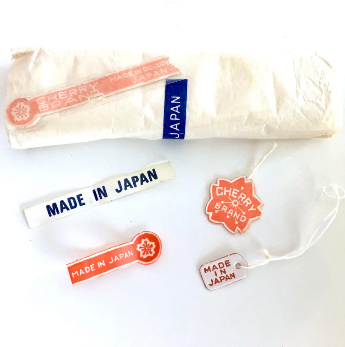 Close-up of Japanese bead labels with colorful text and graphics, showing product names, numbers, and branding in Japanese.