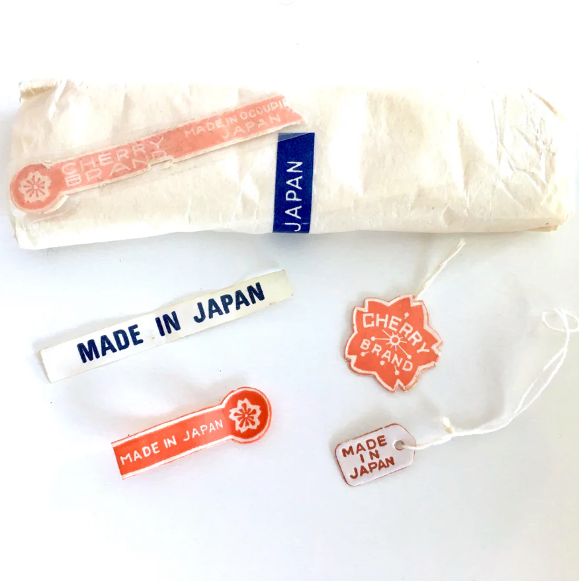 Close-up of Japanese bead labels with colorful text and graphics, showing product names, numbers, and branding in Japanese.