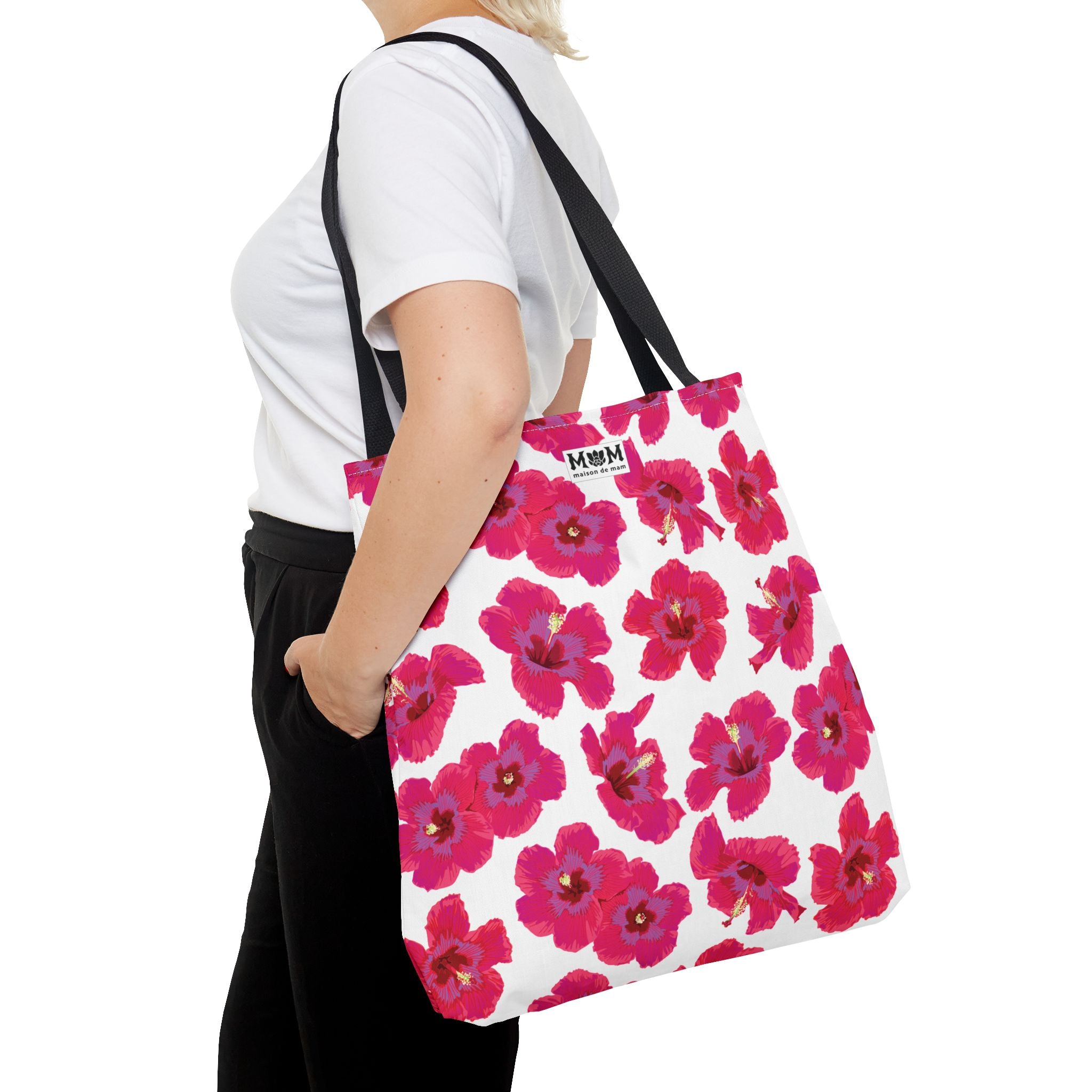 Person carrying a tote bag with pink floral pattern on a white background
