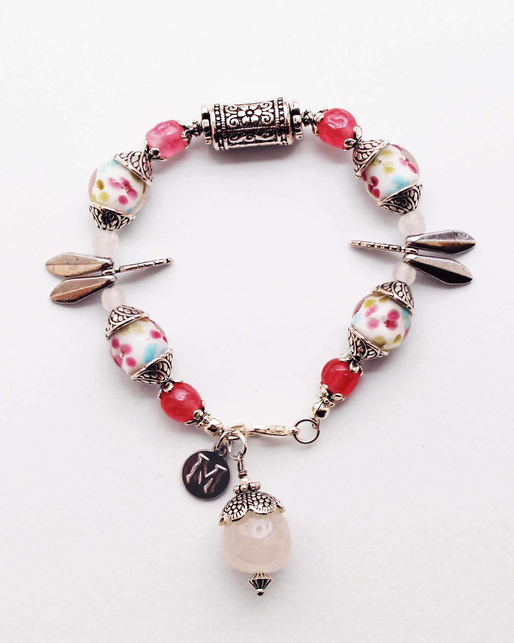 Bracelet with floral beads and charms on a white background