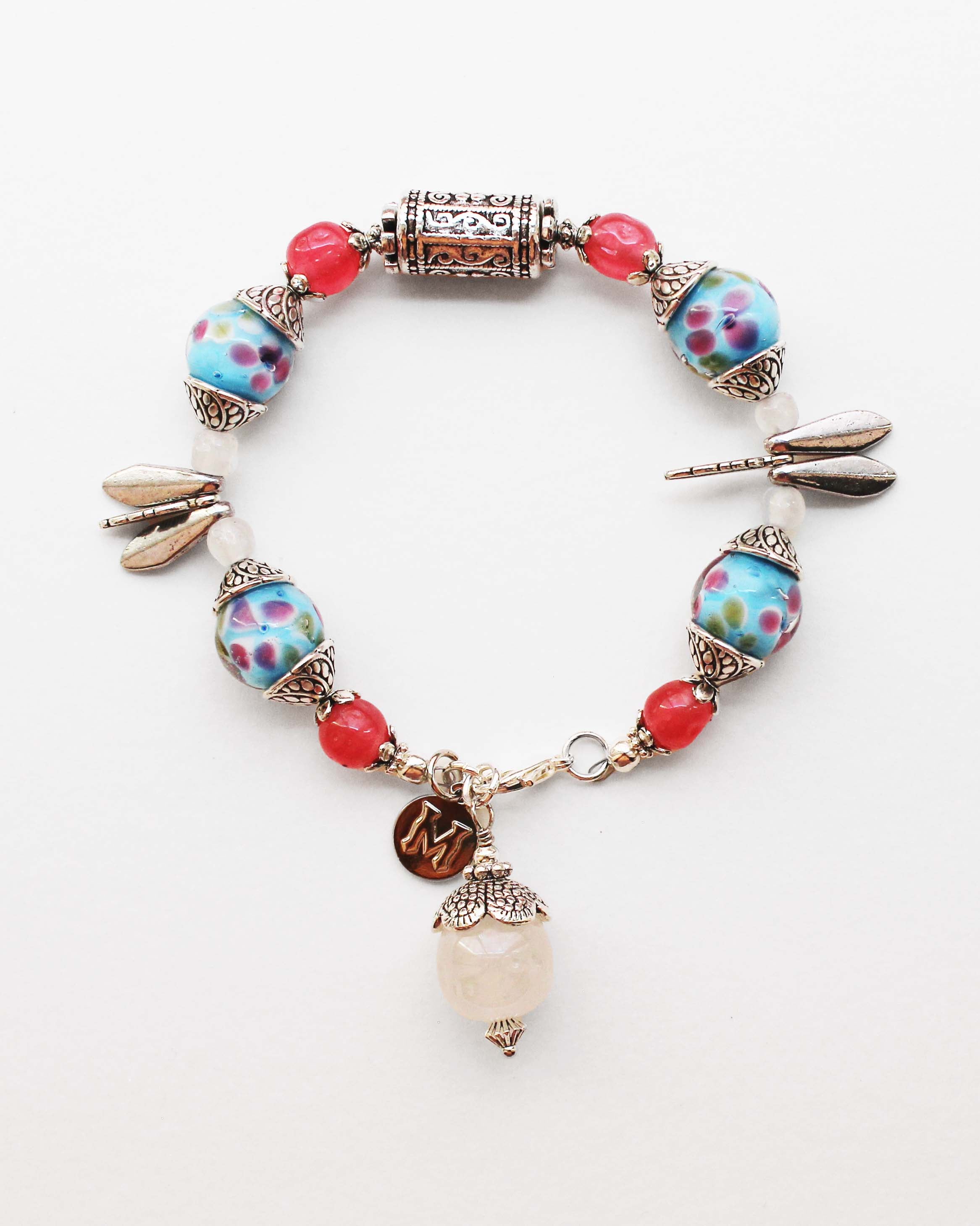 Colorful beaded bracelet with floral designs on a white background
